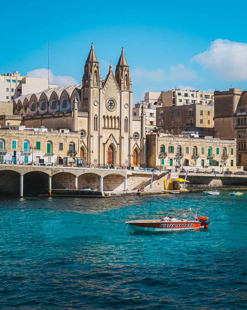 Motorboot auf türkisblauem Wasser in der Balluta Bay