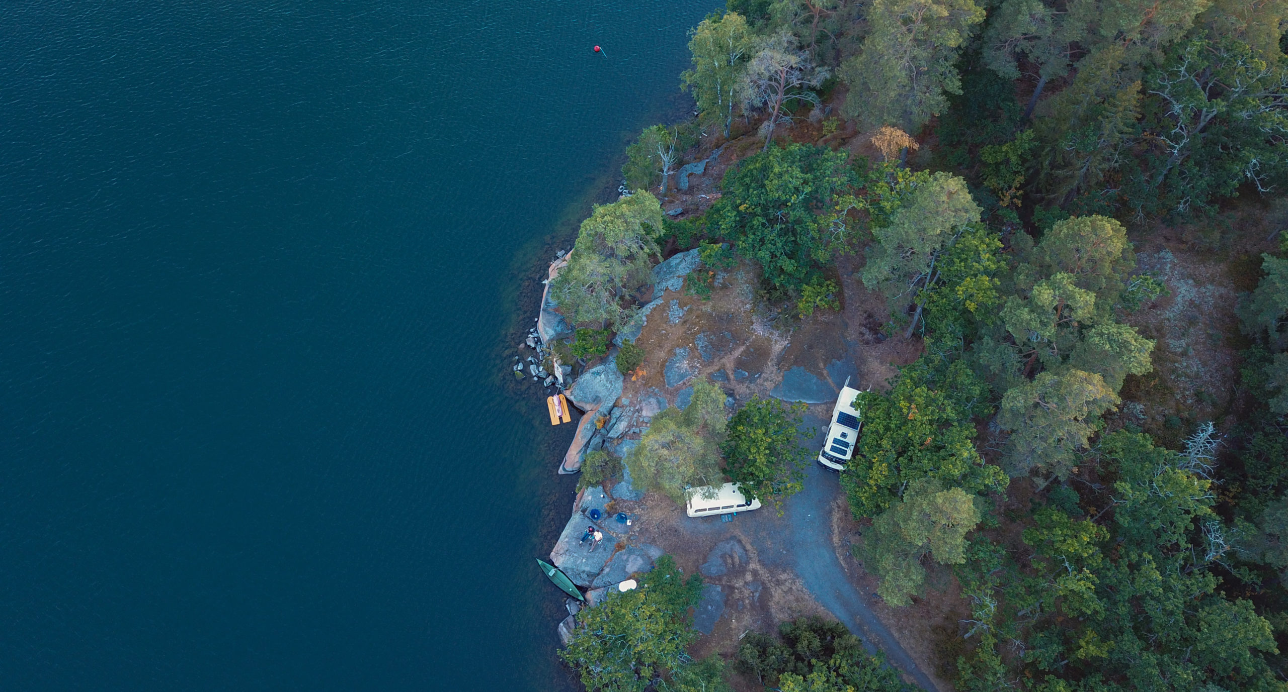 Dronenaufnahme von Stellplatz direkt am Wasser und im Wald
