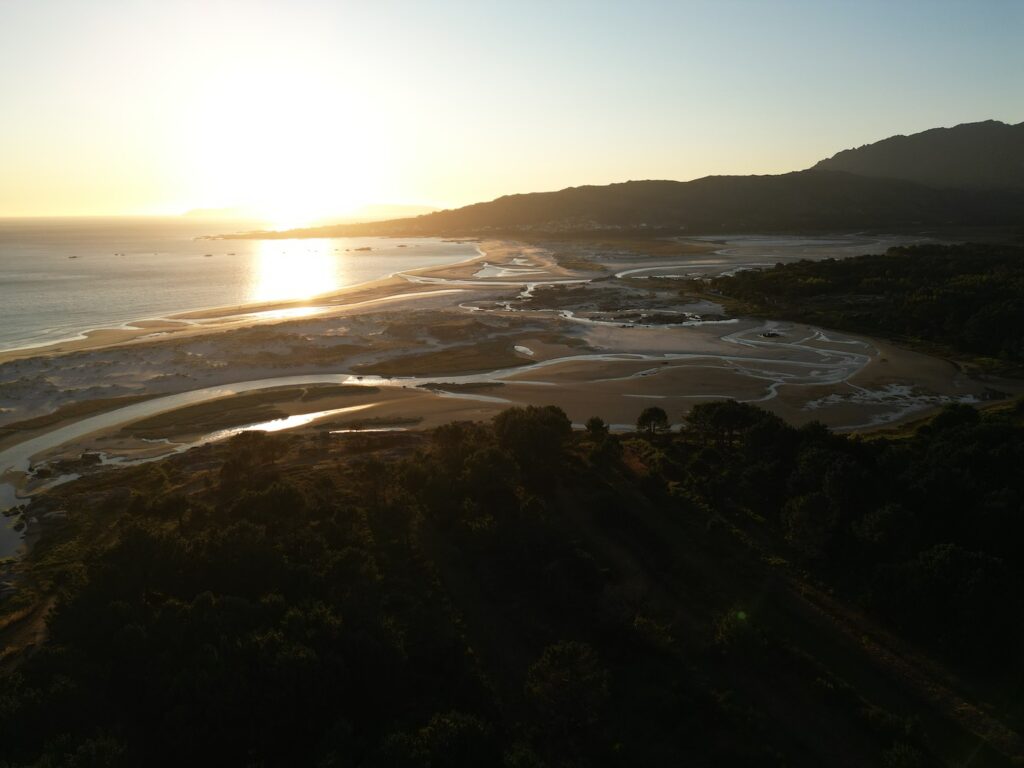 Strand und Lagunenlandschaft in Carnota bei Sonnenuntergang mit dem Kap Fisterre im Hintergrund