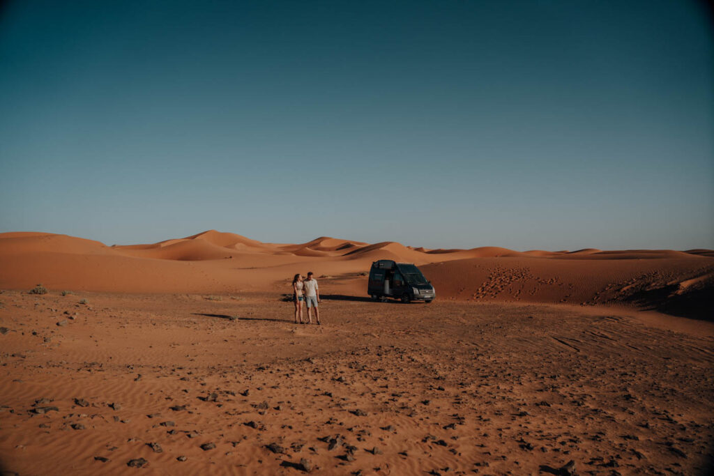 Pärchen übernachtet mit Wohnmobil in der Wüste Marokkos